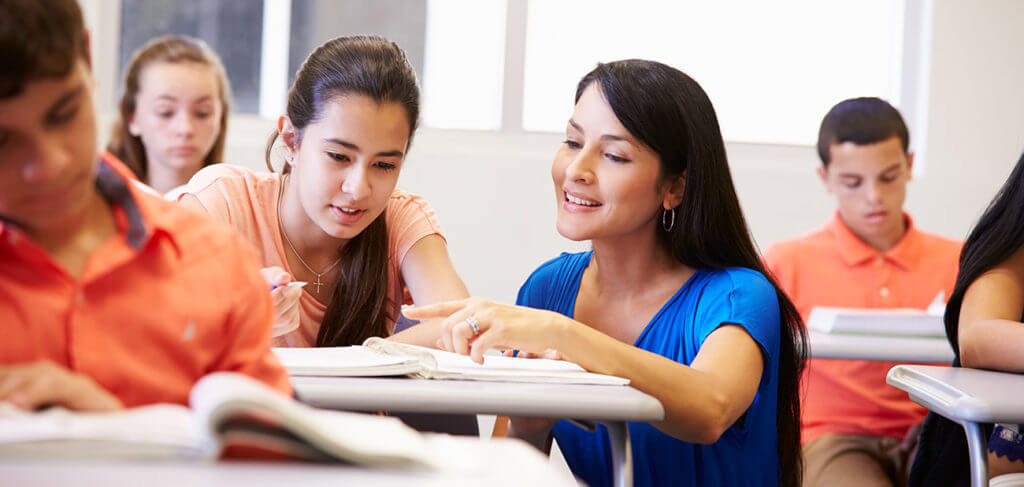 Teacher assisting student at her desk