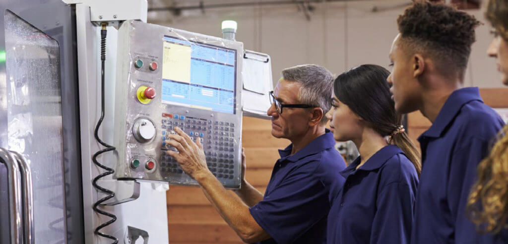 CTE teacher showing students manufacturing equipment