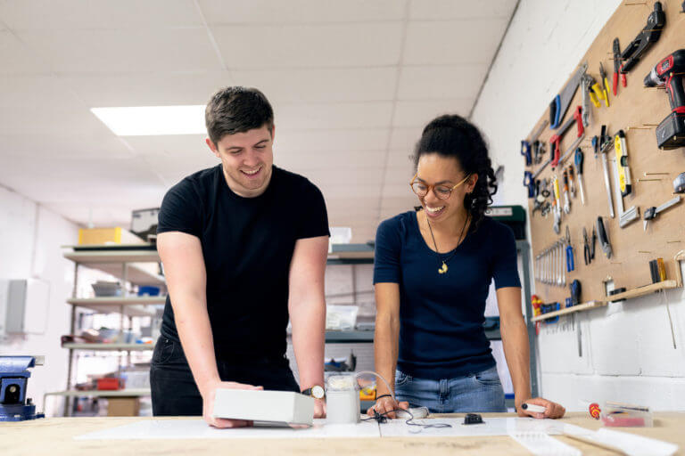 Two young people working on a project together in a maker's space