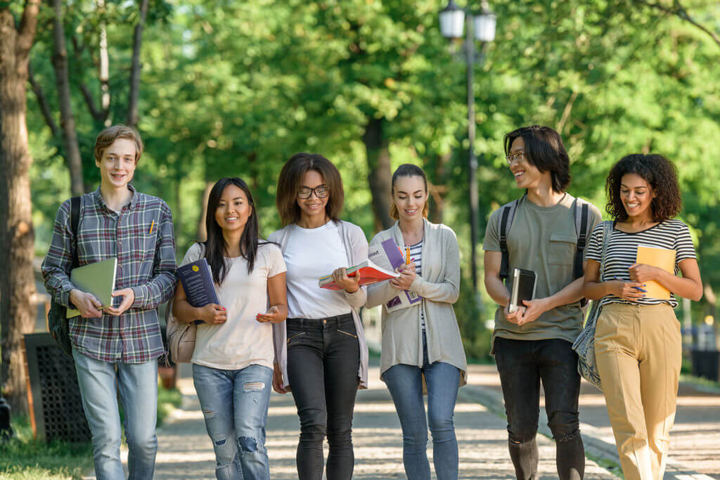 A diverse group of college-age students walking together on campus